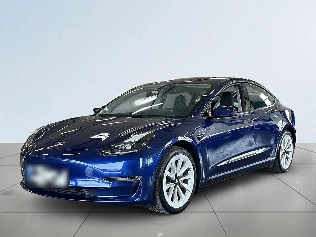 Blå Tesla Model 3 fotograferad snett framifrån